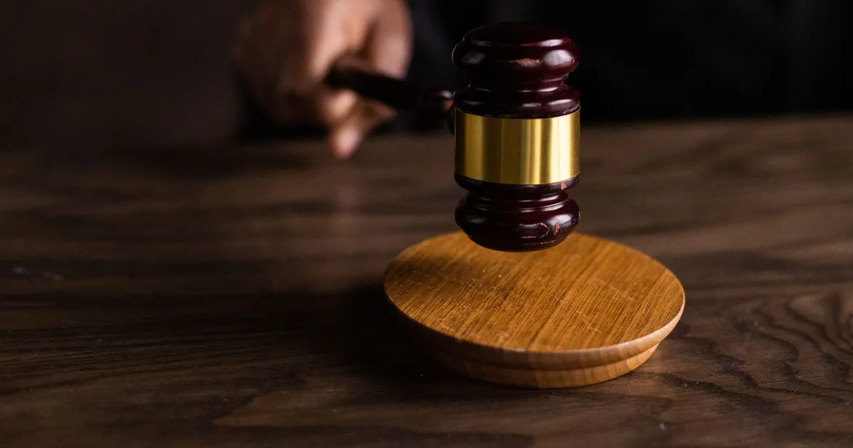 A wooden judge's gavel resting on a sound block